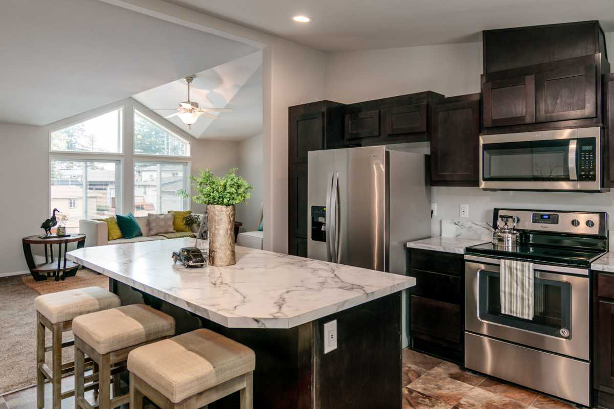 Furnished kitchen with stainless steel appliances, looking out over island